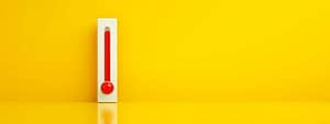 Red thermometer against yellow background