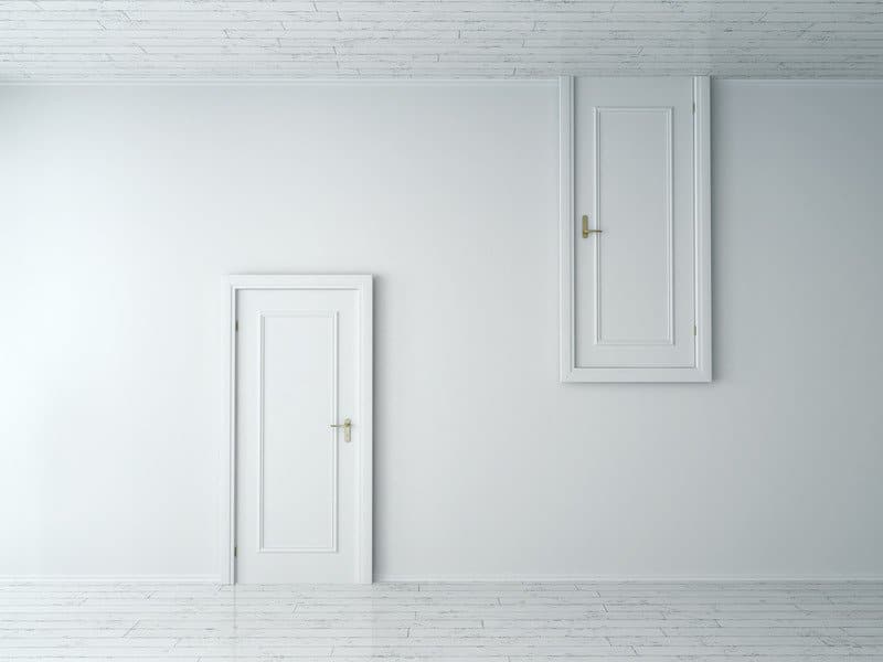 Conceptual Opposite Closed Single Doorways on White Walls at Empty White Room. This image showcases that things aren't always what they appear to be. It's important to recognize our passion and values and pursue them instead of happiness and success.