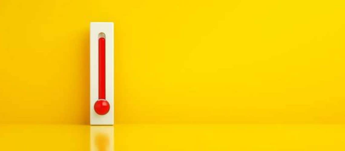 Red thermometer against yellow background