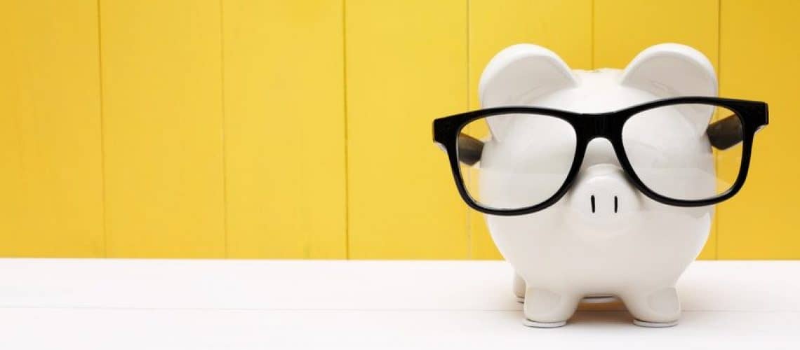 a piggy bank with glasses indicating saving is important in money sense.